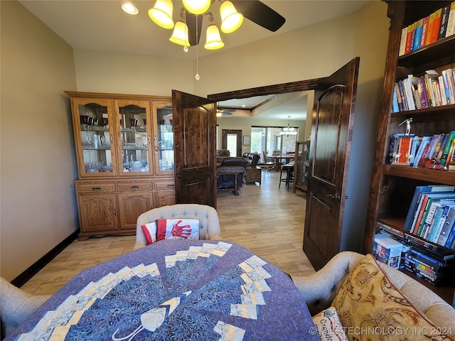 dining area featuring light hardwood / wood-style floors and ceiling fan with notable chandelier