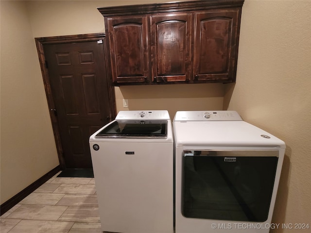 laundry room with cabinets, washer and clothes dryer, and light tile patterned floors