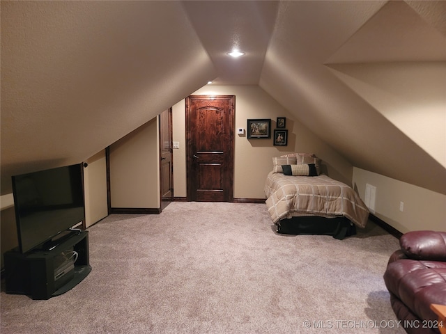 carpeted bedroom with vaulted ceiling