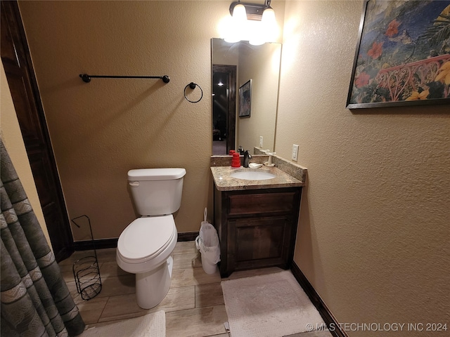 bathroom with toilet, vanity, and tile patterned floors