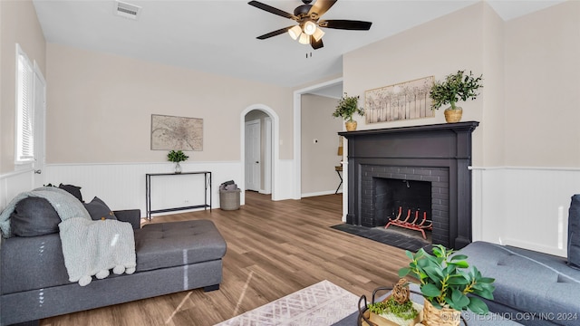 living room with ceiling fan, a fireplace, and hardwood / wood-style floors