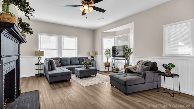 living room featuring hardwood / wood-style floors, a fireplace, and ceiling fan