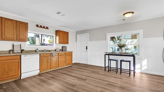 kitchen featuring crown molding, white dishwasher, light hardwood / wood-style flooring, and plenty of natural light