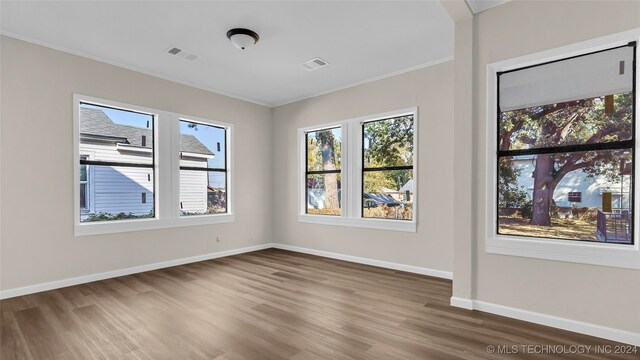 empty room with crown molding and dark hardwood / wood-style floors