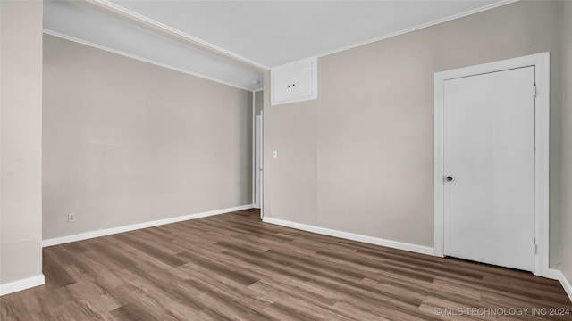 unfurnished room featuring ornamental molding and wood-type flooring