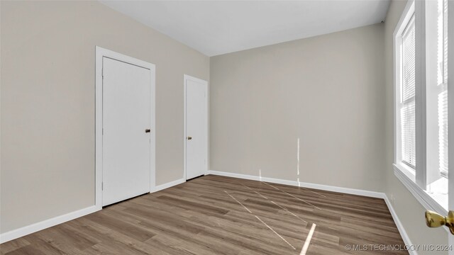 spare room featuring plenty of natural light and hardwood / wood-style floors