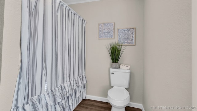 bathroom featuring toilet and wood-type flooring