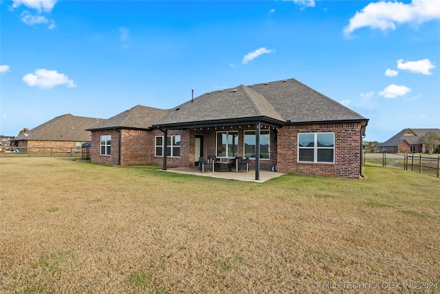 rear view of house featuring a yard and a patio