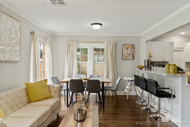 dining area featuring dark wood-type flooring and crown molding