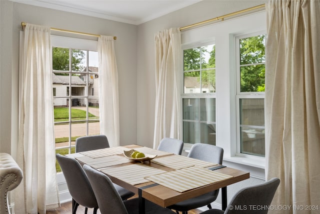 dining space with ornamental molding and hardwood / wood-style floors