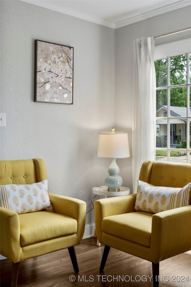 sitting room with ornamental molding and hardwood / wood-style floors