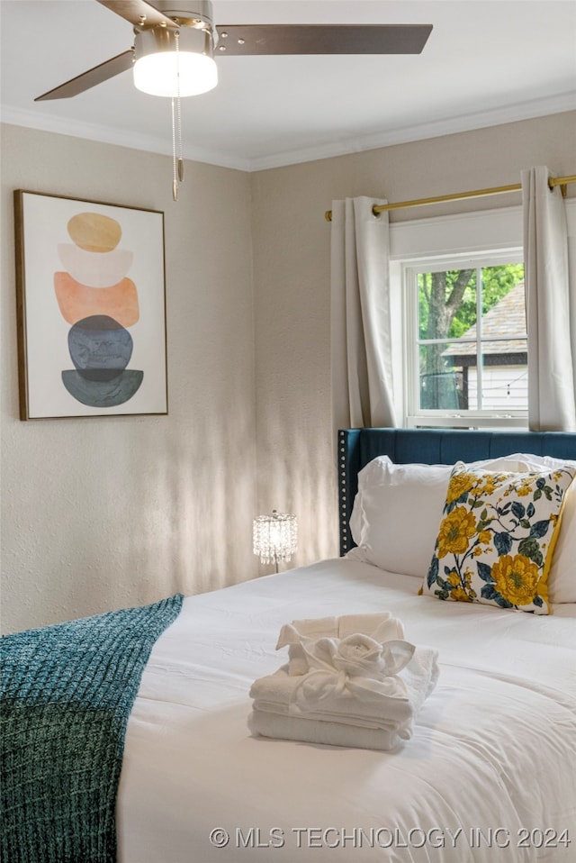 bedroom featuring ceiling fan and ornamental molding