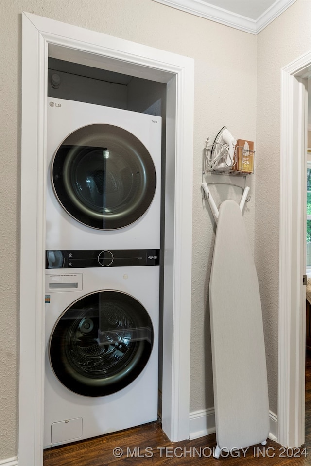 washroom featuring ornamental molding, stacked washer and clothes dryer, and dark hardwood / wood-style floors