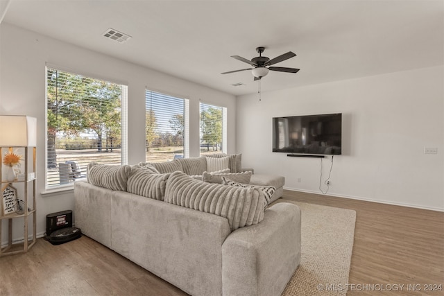 living room featuring ceiling fan, wood-type flooring, and plenty of natural light