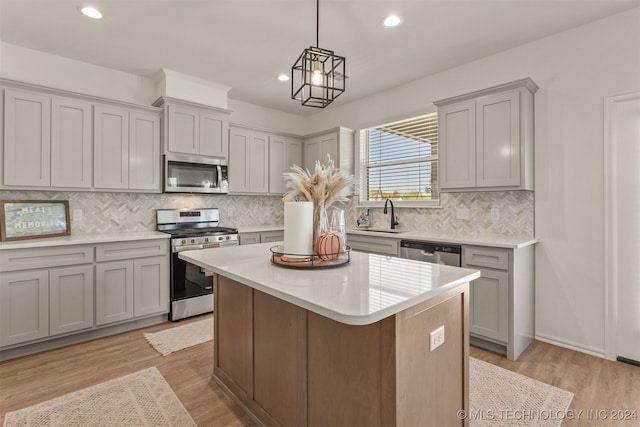 kitchen featuring light hardwood / wood-style flooring, a center island, stainless steel appliances, and backsplash