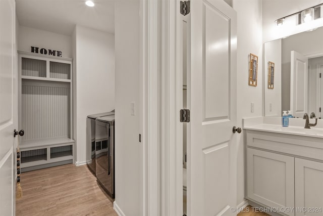 bathroom with vanity, independent washer and dryer, and wood-type flooring