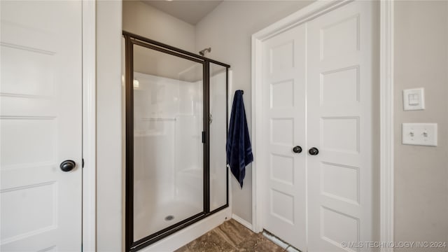 bathroom featuring a shower with door