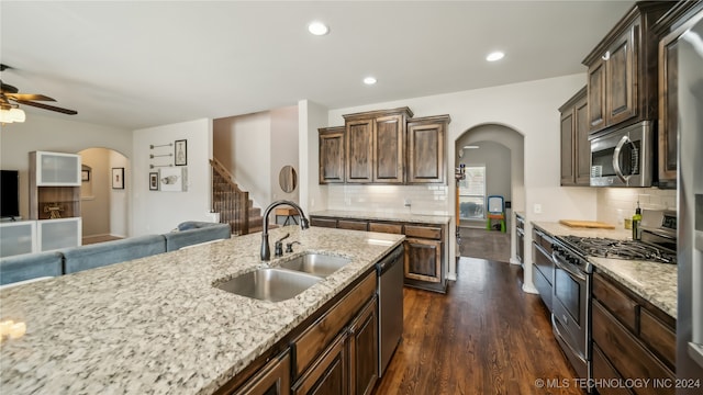 kitchen with sink, appliances with stainless steel finishes, dark hardwood / wood-style floors, and backsplash