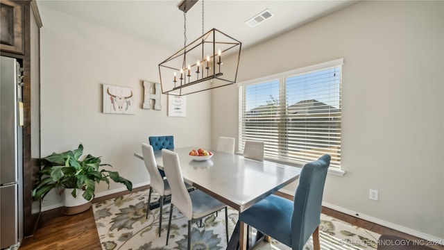 dining space with dark hardwood / wood-style floors and a chandelier