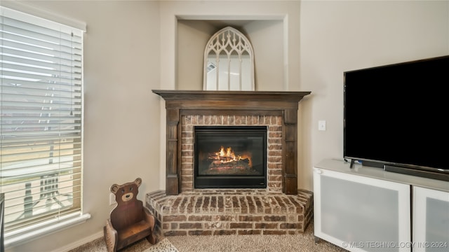 sitting room featuring a brick fireplace and carpet floors