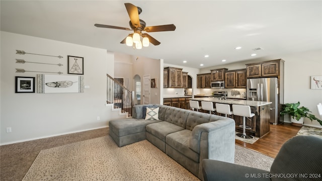 living room featuring ceiling fan and light hardwood / wood-style flooring