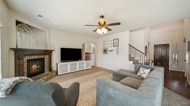 living room featuring ceiling fan, hardwood / wood-style flooring, and a fireplace