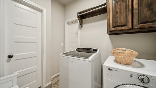 washroom with cabinets and washer and clothes dryer