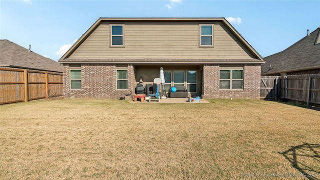 rear view of property featuring a yard and a patio area