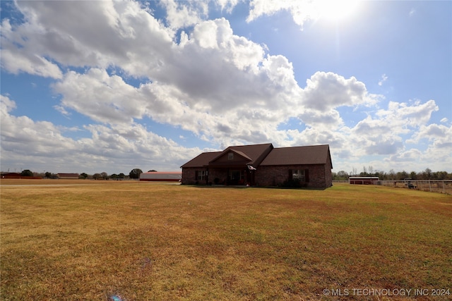 view of front of property with a rural view and a front yard