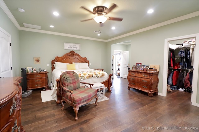 bedroom with ornamental molding, ceiling fan, a spacious closet, a closet, and dark hardwood / wood-style flooring