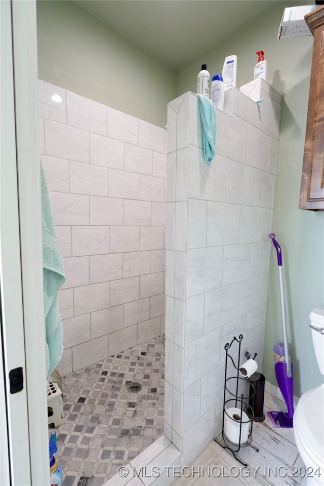 bathroom with toilet and tiled shower