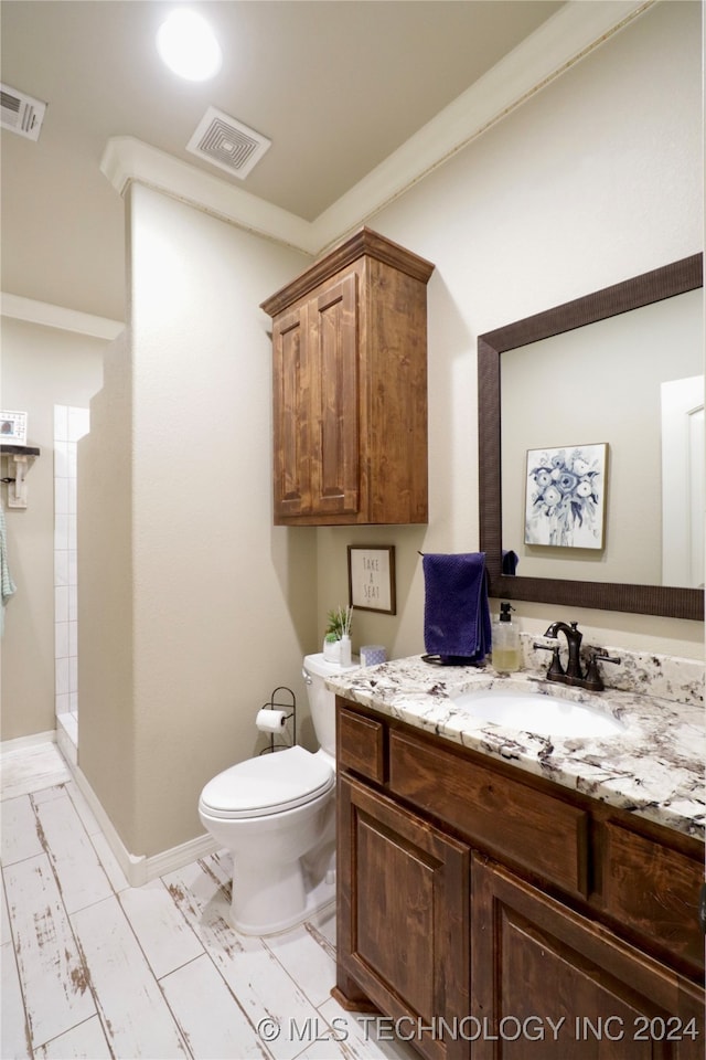 bathroom featuring walk in shower, vanity, and toilet