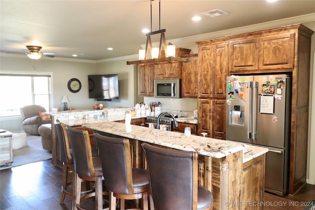 kitchen with a kitchen breakfast bar, dark hardwood / wood-style floors, ceiling fan, a spacious island, and premium appliances