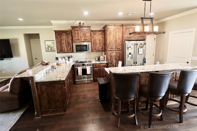 kitchen featuring dark hardwood / wood-style floors, high quality appliances, decorative light fixtures, and a center island