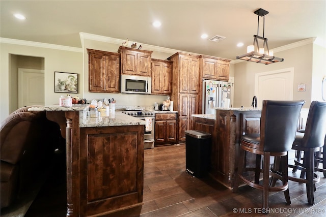 kitchen with stainless steel appliances, ornamental molding, hanging light fixtures, a kitchen island with sink, and dark wood-type flooring