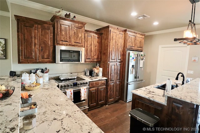 kitchen featuring high end appliances, sink, ornamental molding, dark hardwood / wood-style floors, and decorative light fixtures