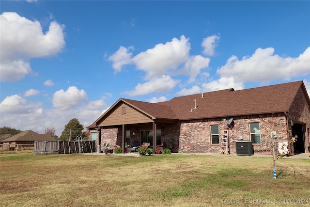 rear view of house with a lawn and a patio area