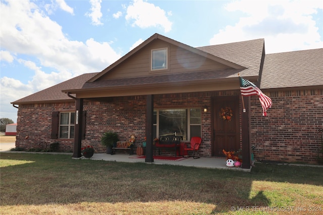 view of front of property featuring a front yard and a patio area