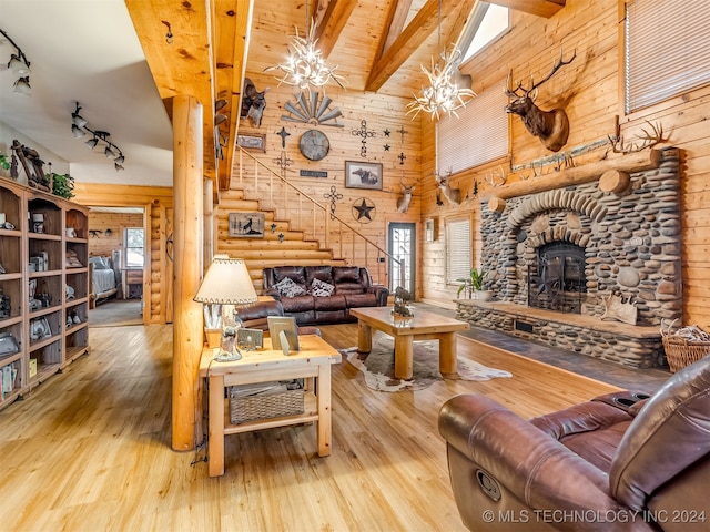 living room with beam ceiling, wood ceiling, a notable chandelier, and light hardwood / wood-style flooring