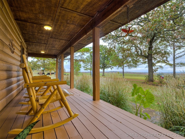 wooden deck featuring a porch and a rural view