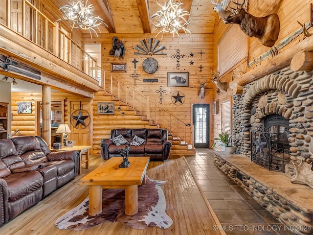 living area featuring hardwood / wood-style floors, stairway, a high ceiling, and a notable chandelier