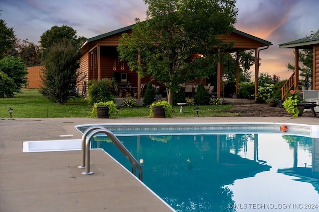 pool at dusk featuring a patio area