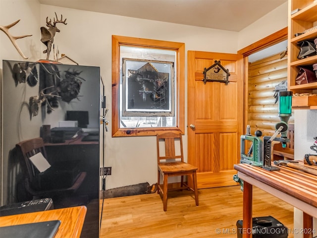 office area with light wood finished floors and log walls