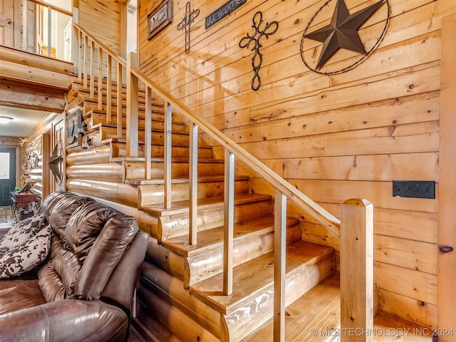 staircase with a high ceiling and wood finished floors