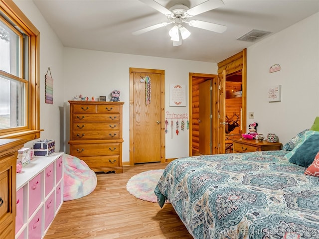 bedroom with ceiling fan, light wood finished floors, and visible vents