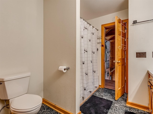 bathroom featuring a shower with shower curtain, baseboards, and toilet