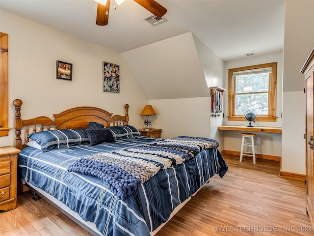 bedroom with lofted ceiling, visible vents, baseboards, and wood finished floors