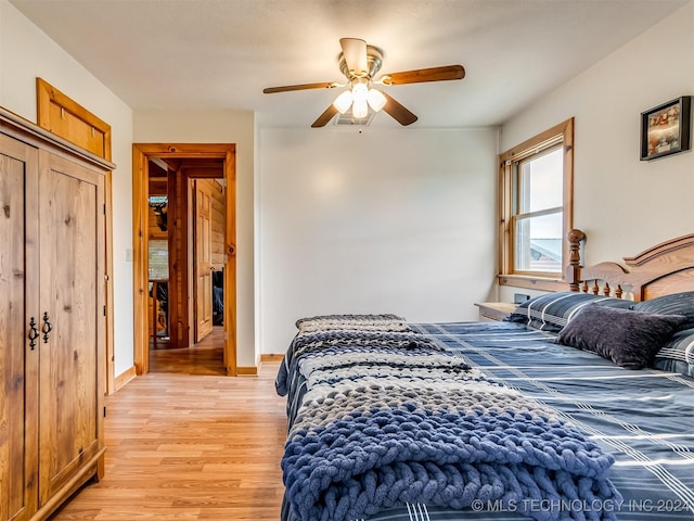 bedroom with light wood-style floors, baseboards, and a ceiling fan