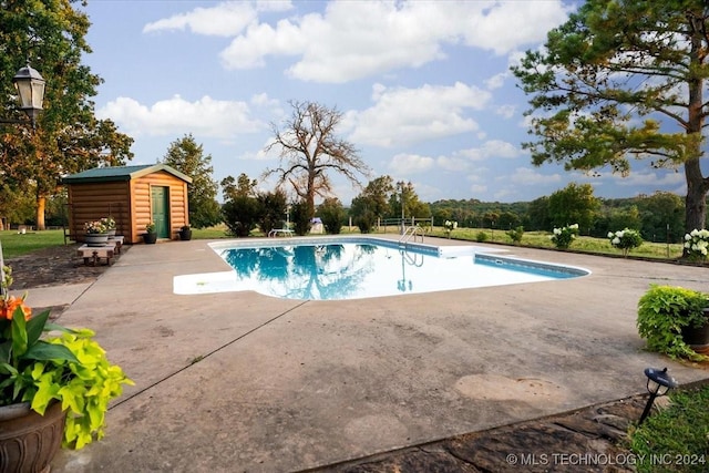 outdoor pool with an outbuilding and a patio