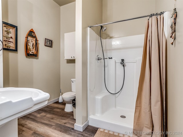 full bathroom featuring curtained shower, wood finished floors, toilet, and baseboards